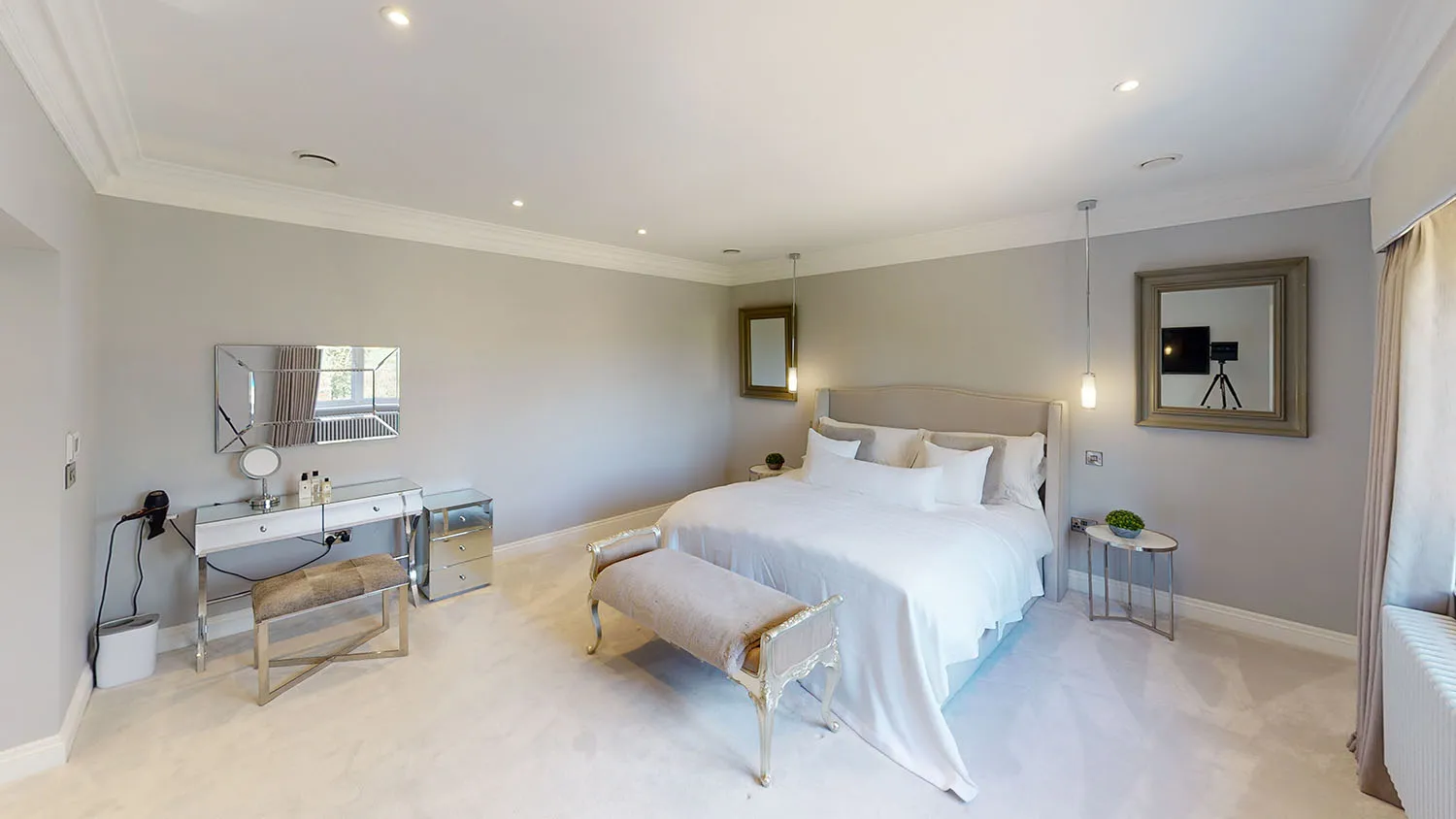 a bedroom with a bed, desk and mirror