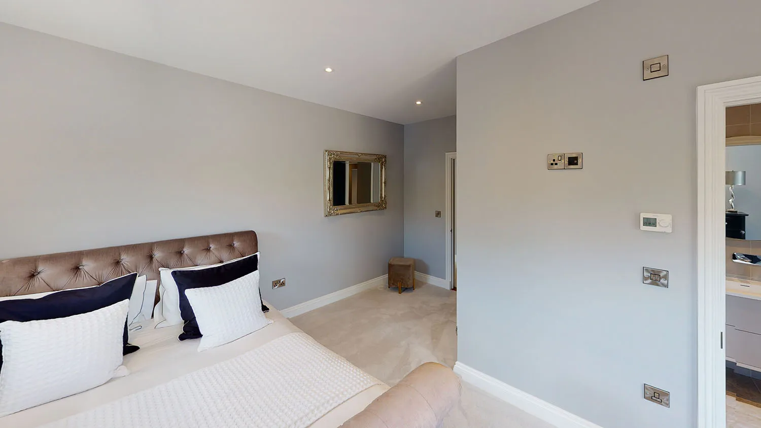 a bedroom with a large bed and a mirror on the wall